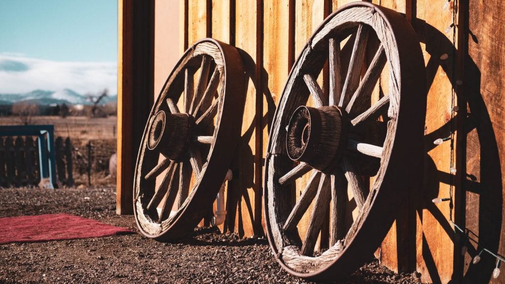 Dos ruedas de madera, que recuerdan a las ruedas de los carros o carretas de época.